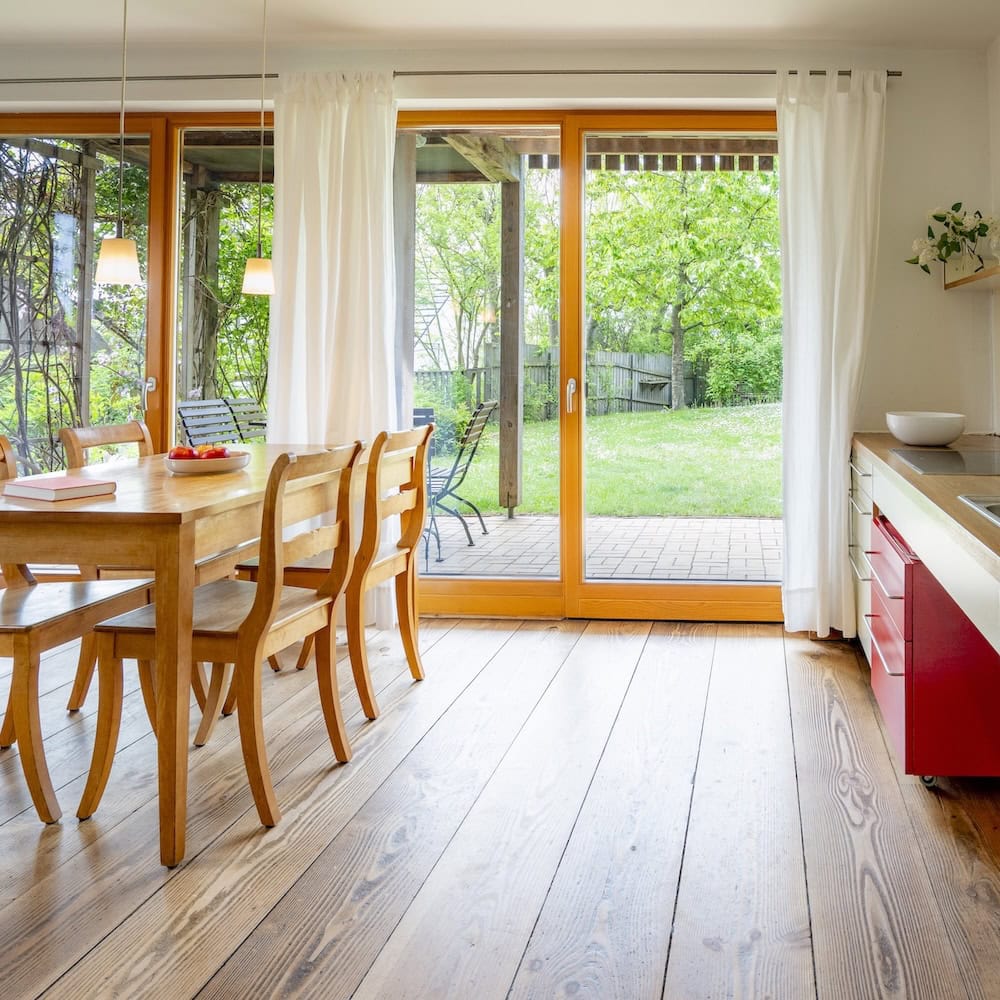 Wohnraum und Küchenzeile mit Massivholzmöbeln und Holzdielen und direktem Zugang zum Garten, Ferienwohnung 1, Apfelgarten Usedom Reetzow, barrierefrei