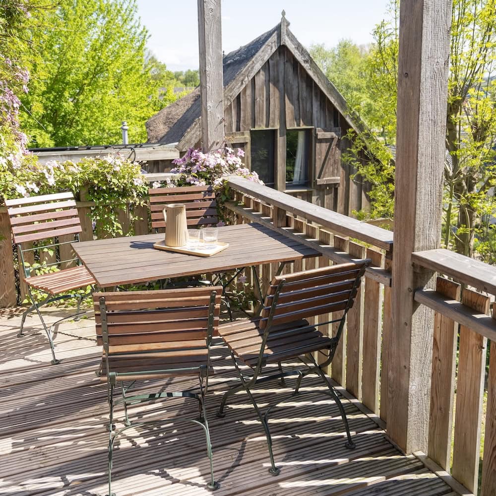 Großer Balkon mit Holzmöbeln, Blick in den Garten und zur Nachbarscheune, Ferienwohnung 3, Apfelgarten Usedom Reetzow