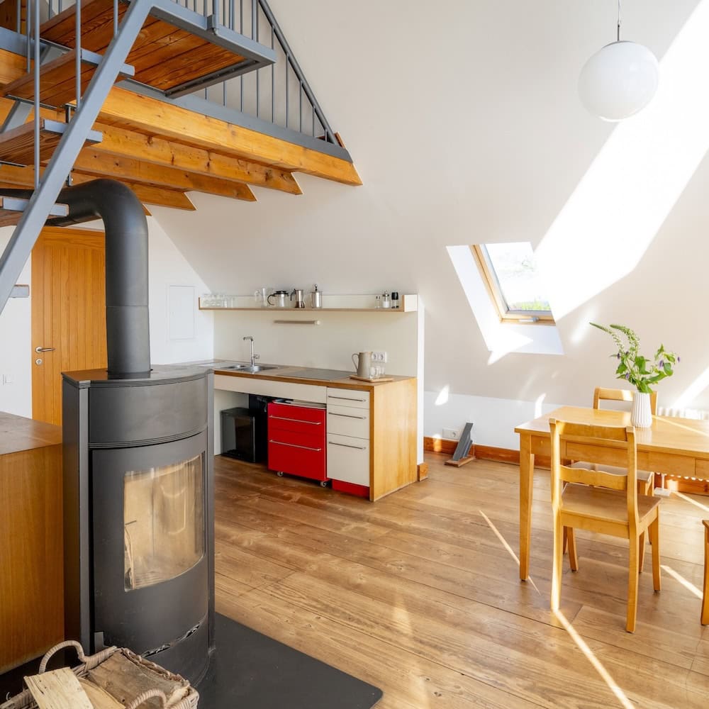 Wohnraum mit Kaminofen, Küchenzeile, modernen Massivmöbeln und Holzdielen, Ferienwohnung 6, Apfelgarten Usedom Reetzow