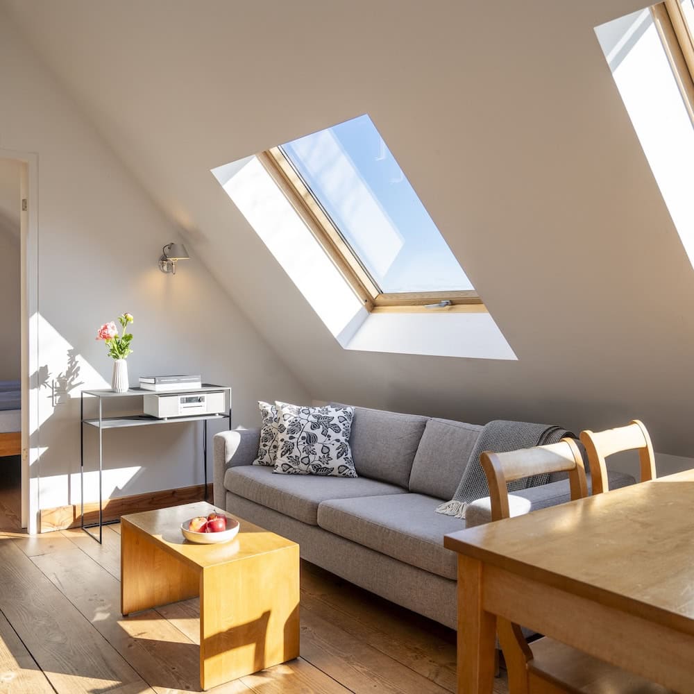 Wohnraum mit Sofa und Esstisch und großen Dachfenstern, Ferienwohnung 5, Apfelgarten Usedom Reetzow